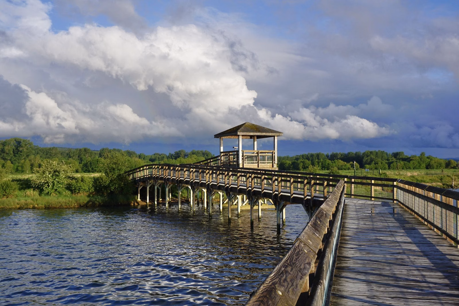 A long wooden boardwalk with a covered lookout over water near Olympia